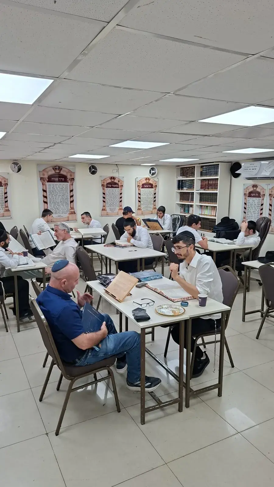לומד ואברך יושבים יחד מול גמרא בבית המדרש